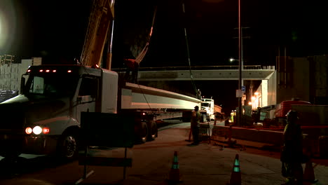 Huge-steel-girders-are-delivered-during-work-on-a-freeway-overpass-at-night-in-Los-Angeles-in-time-lapse