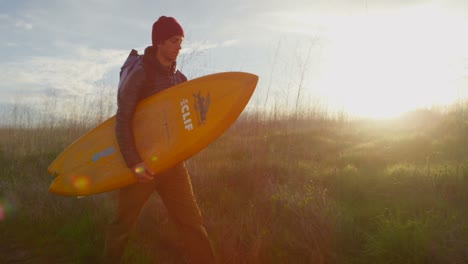 Ein-Surfer-Trägt-Sein-Board,-Während-Er-Zu-Einem-Abgelegenen-Surfspot-In-Einem-Küstengebiet-Wandert-2
