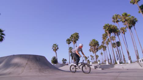 Low-Angle-View-Eines-BMX-Radfahrers,-Der-Einen-Sprung-Und-Eine-Drehung-In-Einem-Skatepark-Ausführt