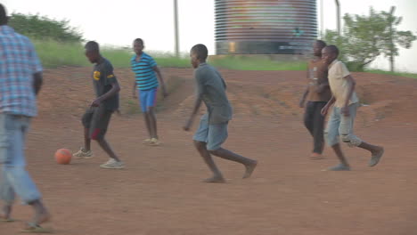 Los-Niños-Africanos-Juegan-Al-Fútbol-En-Un-Campo-De-Tierra
