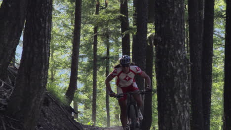 A-man-rides-a-mountain-bike-fast-through-a-dense-forest