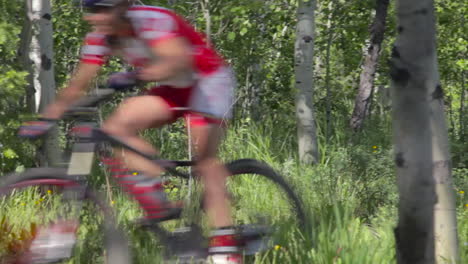 A-man-rides-a-montaña-bike-fast-through-a-dense-forest-3