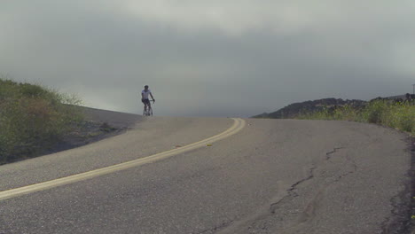 Slow-motion-shot-of-montaña-bike-rider-moving-along-California-highway-1