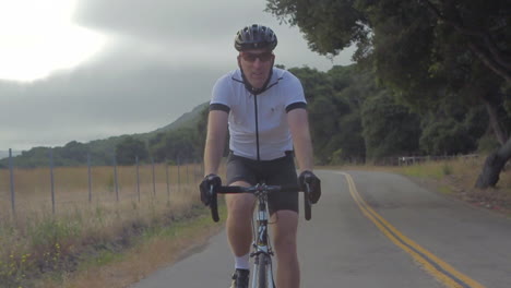 Slow-motion-shot-of-mountain-bike-rider-moving-along-California-highway-1-2