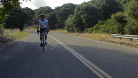 Traveling-slow-motion-shot-of-mountain-bike-rider-moving-along-a-highway-1