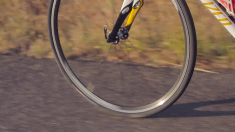 Traveling-slow-motion-shot-of-mountain-bike-wheels-moving-a-long-a-paved-road