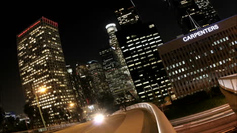 Timelapse-of-Los-Angeles-city-traffic-with-illuminated-skyscrapers-towering-behind