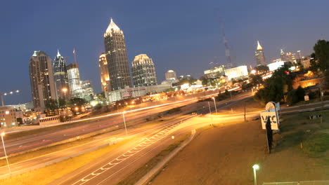 Die-Lichter-In-Der-Innenstadt-Von-Atlanta-Georgia-Und-Den-Umliegenden-Autobahnen-Erhellen-Sich,-Wenn-Der-Abend-In-Die-Nacht-übergeht