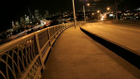 Pedestrians-and-traffic-cross-a-bridge-in-Seattle-at-night