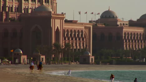 People-walk-near-a-mosque-in-Abu-Dhabi-United-Arab-Emirates