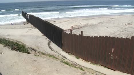 Eine-Familie-Spielt-Am-Strand-Neben-Der-Grenzmauer-In-Tijuana
