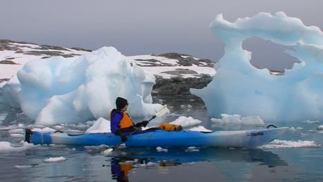 A-man-paddles-a-kayak-through-the-Arctic-or-Antarctica-region