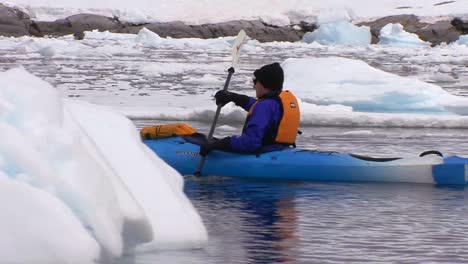 A-man-paddles-a-kayak-through-the-Arctic-or-Antarctica-region-1