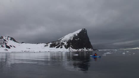 A-man-paddles-a-kayak-through-a-gorgeous-Arctic-or-Antarctica-region