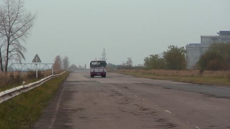 Ein-Bus-Fährt-Auf-Einer-Verlassenen-Straße-In-Der-Nähe-Des-Kernkraftwerks-Tschernobyl-Vorbei