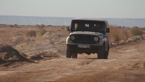 Ein-Alter-Jeep-Fährt-Auf-Einer-Straße-In-Der-Nähe-Des-Aralsees-In-Kasachstan-Oder-Usbekistan-Vorbei