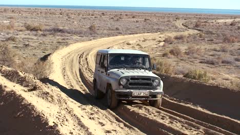 Ein-Alter-Jeep-Fährt-Auf-Einer-Tief-Ausgefahrenen-Straße-In-Der-Nähe-Des-Aralsees-In-Kasachstan-Oder-Usbekistan