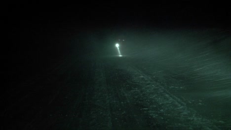 A-person-with-a-flashlight-walks-through-a-blizzard