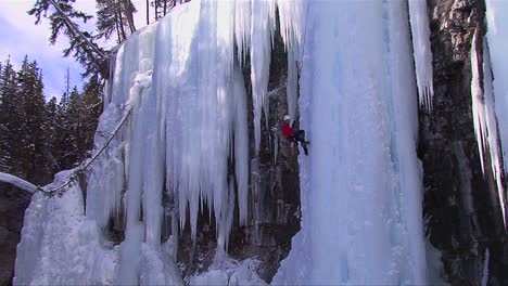 An-extreme-wide-shot-of-a-man-climbing-a-frozen-waterfall