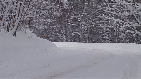 Ein-Auto-Fährt-Auf-Einer-Verschneiten-Bergstraße