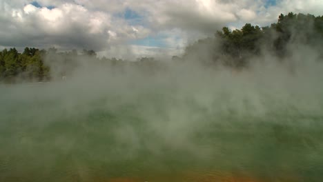 Steam-rises-off-a-geothermal-lake-in-New-Zealand\'s-Rotorua-region