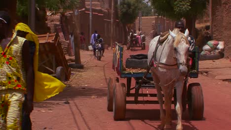 La-Gente-Camina-Y-Monta-En-Carritos-De-Caballos-Por-Las-Calles-De-La-Ciudad-De-Malí-África-1