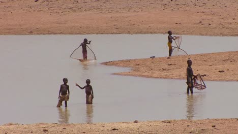 Children-use-conical-nets-to-catch-fish-in-a-pool-along-a-river-in-mali-Africa-1