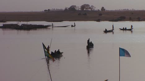 Men-row-boats-in-silhouette-on-a-river-in-mali