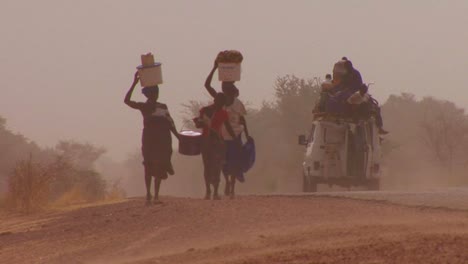Las-Mujeres-Caminan-Cargando-Mercancías-Sobre-Sus-Cabezas-A-Través-Del-Desierto-Del-Sahara-En-Malí-2