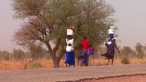 Las-Mujeres-Caminan-Cargando-Mercancías-Sobre-Sus-Cabezas-A-Través-Del-Desierto-Del-Sahara-En-Malí-3