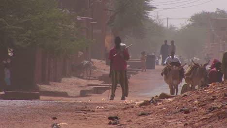 La-Gente-Camina-Por-Una-Carretera-A-Través-Del-Desierto-Del-Sahara-En-Malí-Durante-Una-Tormenta-De-Viento