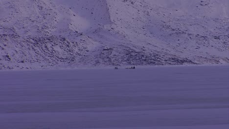 Un-Esquimal-Trineo-Tirado-Por-Perros-Cruza-La-Tundra-Helada-En-La-Distancia