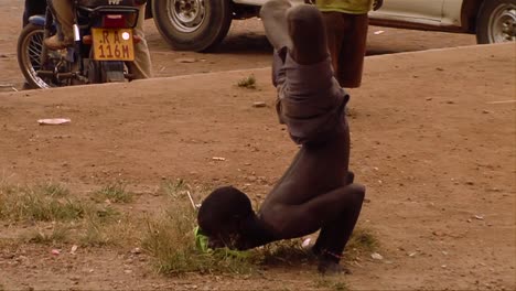 Ein-Afrikanischer-Mann-Macht-In-Einem-Kleinen-Dorf-Einen-Skurrilen-Rap-tanz-Mit-Gekreuzten-Beinen