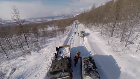 Antenne-Von-Autos-Und-Lastwagen,-Die-In-Der-Wildnis-Sibiriens-Im-Schnee-Stecken