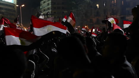Protestors-wave-flags-at-a-large-nighttime-rally-in-Cairo-Egypt