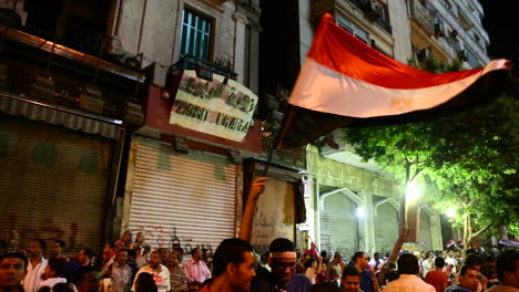 Los-Manifestantes-Ondean-Banderas-En-Un-Mitin-Nocturno-En-El-Cairo,-Egipto