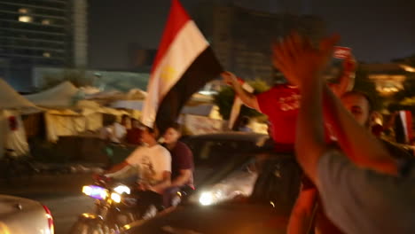 A-man-waves-a-flag-from-a-car-at-a-nighttime-rally-in-Cairo-Egypt