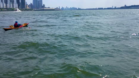 Ein-Schwimmer-Schwimmt-Den-Hudson-River-Mit-New-York-City-Im-Hintergrund-Hoch