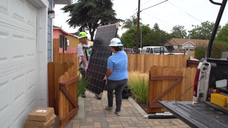 Workers-Install-Solar-Panels-On-The-Roof-Of-A-Middle-Class-House