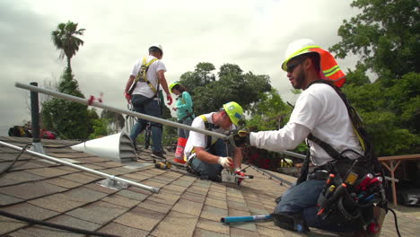 Arbeiter-Installieren-Sonnenkollektoren-Auf-Dem-Dach-Eines-Mittelklassehauses-1