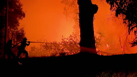 Ein-Feuerwehrmann-Steht-In-Silhouette-Und-Bekämpft-Einen-Riesigen-Hangbrand-Während-Des-Urlaubsfeuers