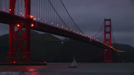 Ein-Wurmblick-Auf-Die-Golden-Gate-Bridge-Bei-Nacht-Mit-Ihren-Lichtern,-Die-Sich-Im-Wasser-Spiegeln