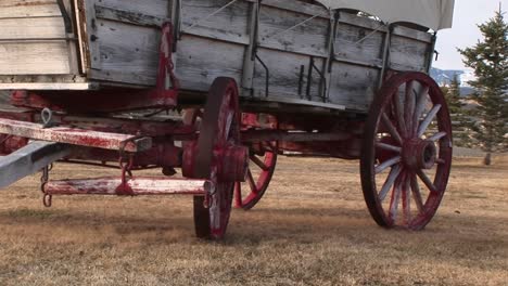 A-Close-Look-At-The-Lower-Half-Of-A-Covered-Wagon-With-Its-Wagon-Wheels-Painted-Red