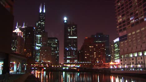 A-Commuter-Train-Moves-Slowly-Across-The-Brilliant-Chicago-Skyline-At-Night