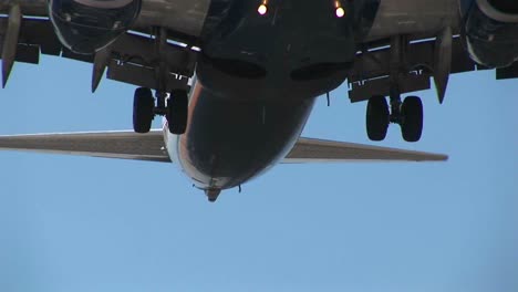 An-Airplane-Flies-Over-Power-Lines-With-Its-Landing-Gear-Down-In-Preparation-For-Landing