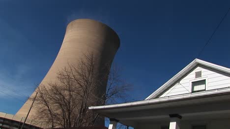 The-Roof-Of-A-Residential-Home-Looks-In-Close-Proximity-To-A-Nearby-Nuclear-Power-Plant