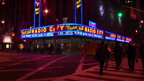 Radio-City-Música-Hall-At-Night-With-Lights-Traffic-And-Pedestrians