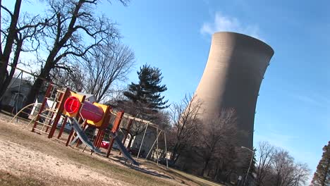 The-Camera-Tilts-To-Show-A-Playground-And-Nuclearpower-Plant-Near-Each-Other