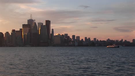 Waterfront-Perspective-Of-The-Toronto-Skyline-During-The-Goldenhour-With-Boats-Moving-Across-Lake-Ontario