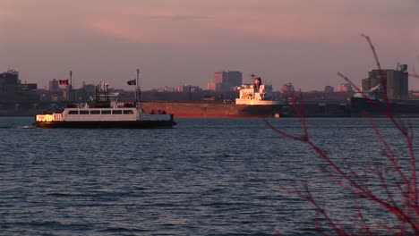 A-Canadian-Passenger-Boat-Travels-Past-A-Lake-Freighter-On-Lake-Ontario